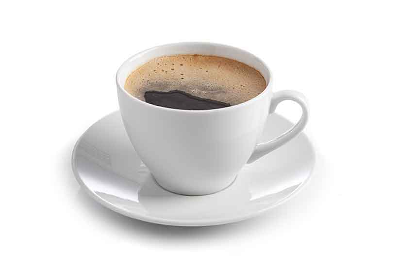 Café negro caliente en taza blanca con platillo.