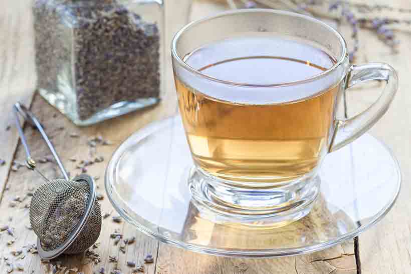 Té de lavanda en vaso sobre un escritorio.