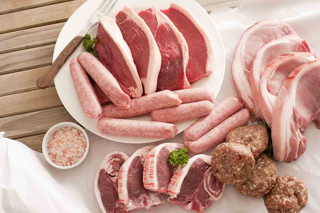 Plato y mesa de carne: salchichas, chips de cerdo, albóndigas.