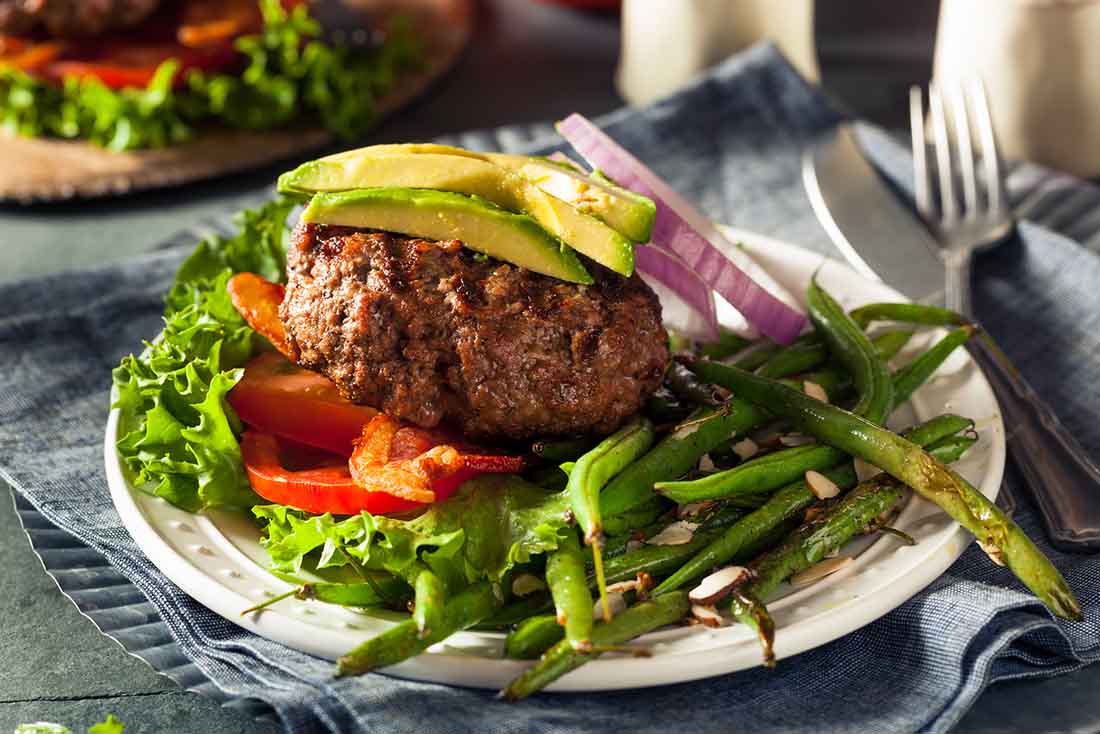 Hamburguesa de aguacate sin fondo con ensalada fresca.