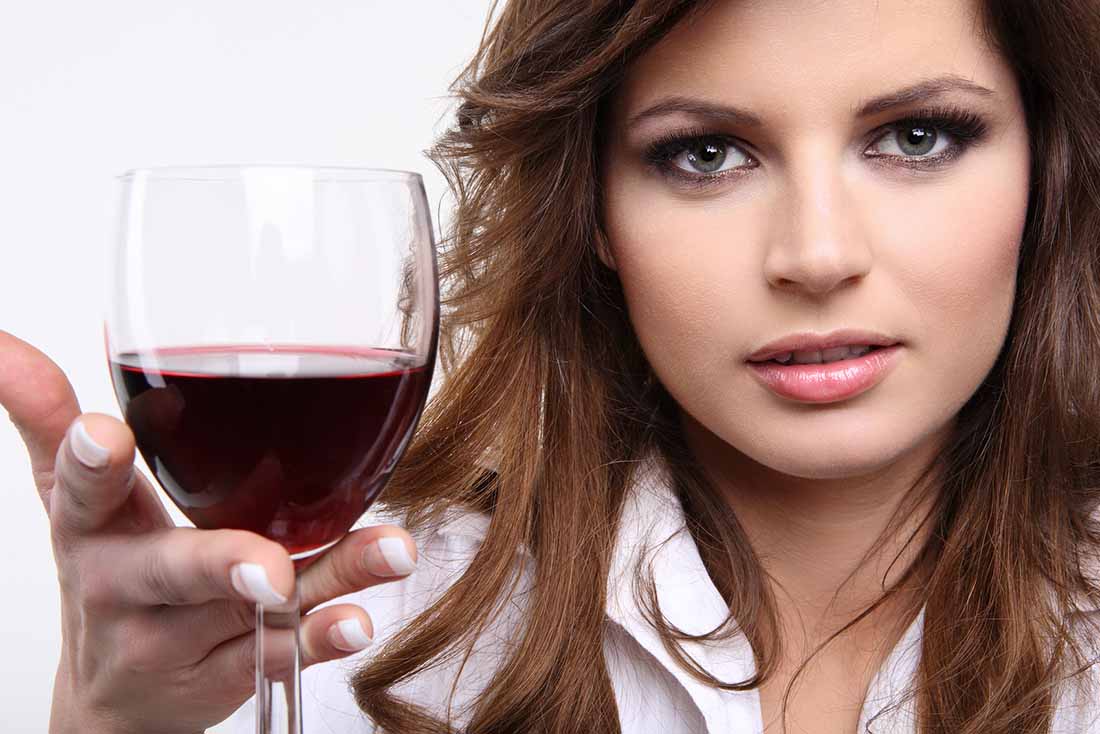 Mujer sosteniendo una copa de vino tinto.