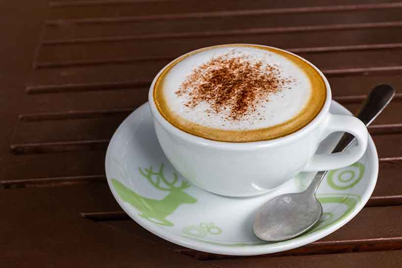 Una taza de manteca de cacao Cafe Mocha en platillo.