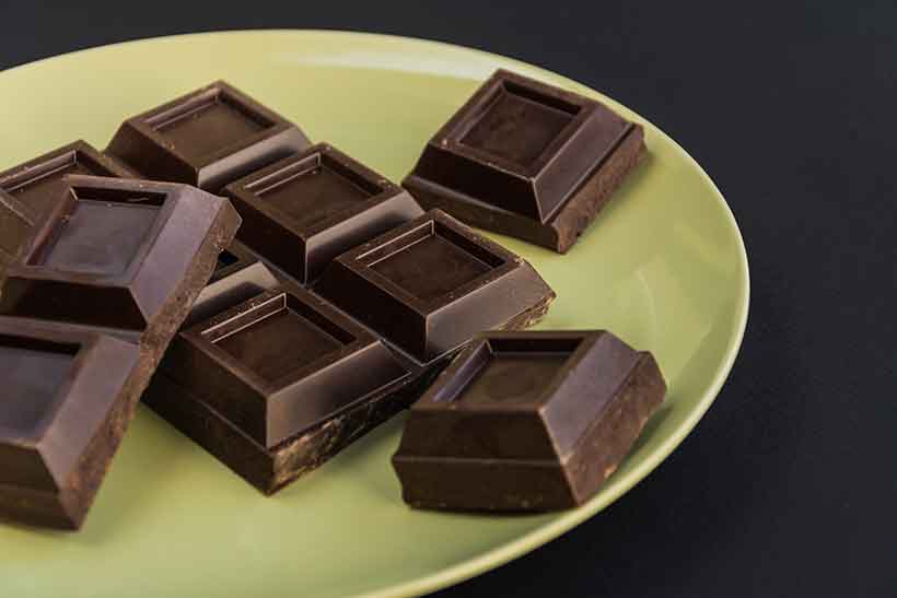 Trozos de barra de chocolate oscuro casera en un plato.