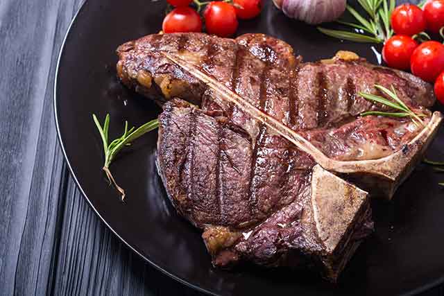 Filete de T-bone molido en plato negro.