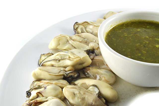 Ostras Frescas En Un Plato Con Salsa Picante.