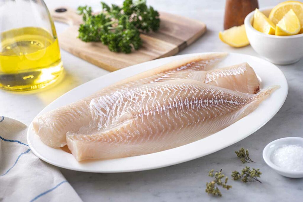 Algunos filetes de eglefino en un plato blanco.